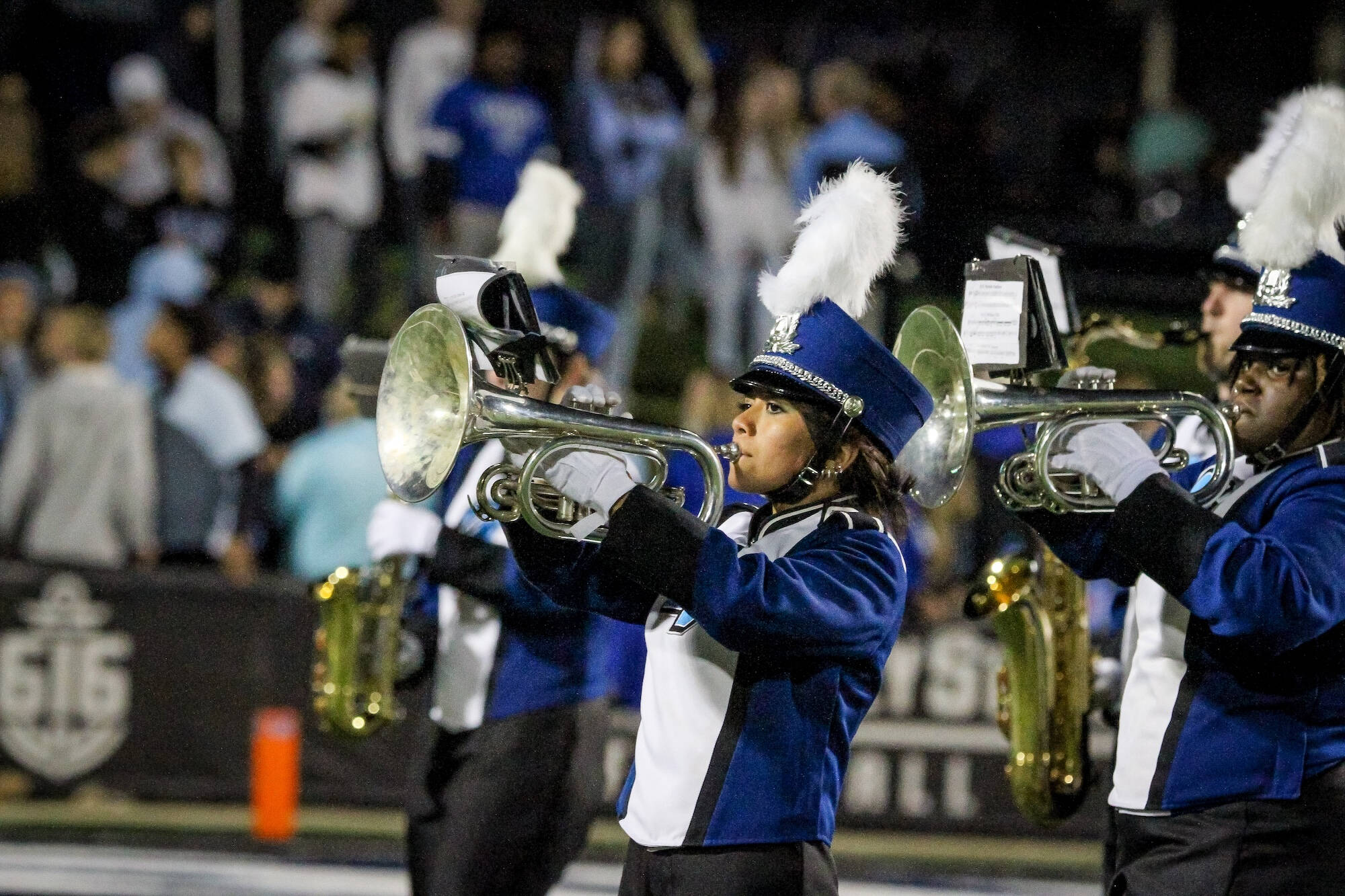 Baritone player in uniform, marching at lubbers stadium. Other players blurred in the background